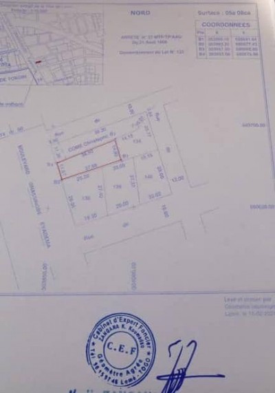 1 lot cloturé avec titre foncier en cours au bord du goudron